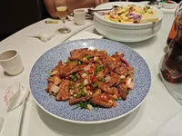 Мясное блюдо с овощами на синей тарелке